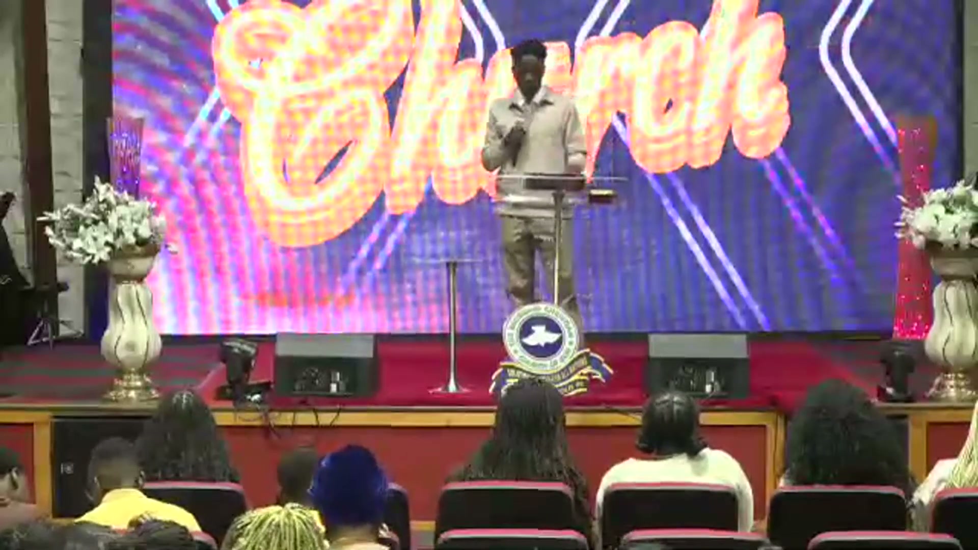 Pastor Ayodeji Obajolu preaching from the pulpit before the congregation during a Sunday service